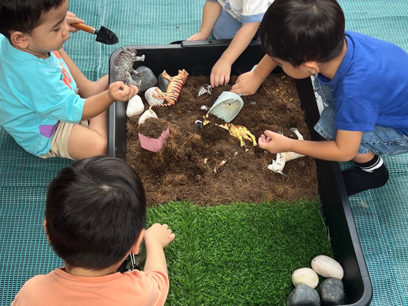 Children exploring a sensory discovery tray at Little & Loved